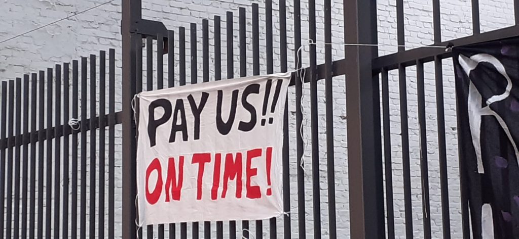 A banner from a Street Fleet protest in Berlins that reads "Pay us!! On Time!"