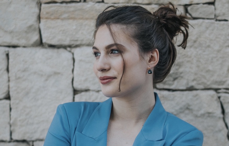 An image of Konstantina Psoma, cofounder and CEO of Kaedim, one of Sifted's under the radar Greek startups to watch. She's wearing a blue blazer, and has her, which is brown, hair tied up