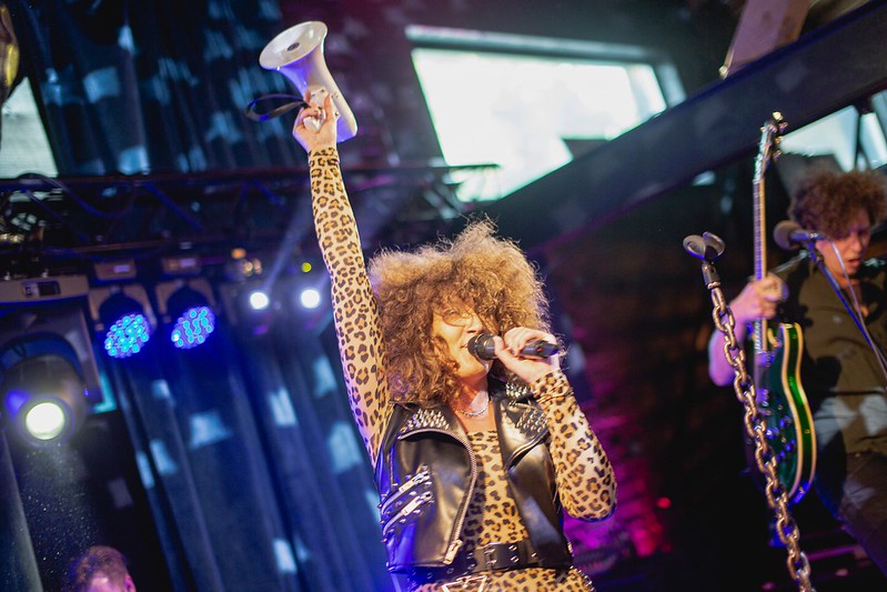 An image of a female singer holding a megaphone aloft at the startup conference Latitude59, one of the tech conferences to attend in 2022