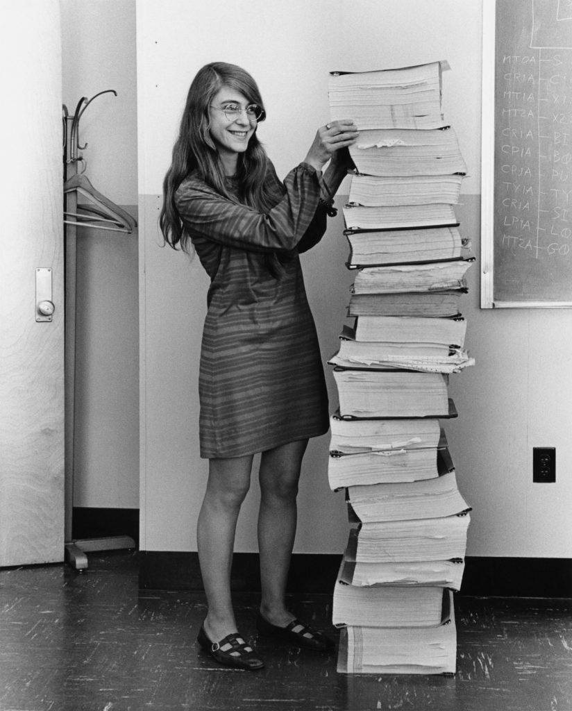 Margaret Hamilton el 1969 al costat del codi que va escriure per aterrar l'Apol·lo a la Lluna