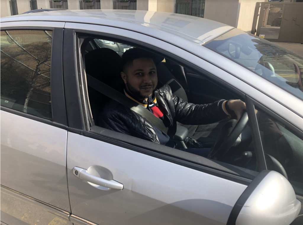 Yaseen Aslam behind the steering wheel of his car