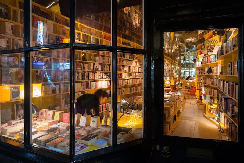 Looking in to Second Home's bookshop Libreria lit up at night