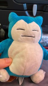 A landscape photo of a blue and white Snorlax plush toy