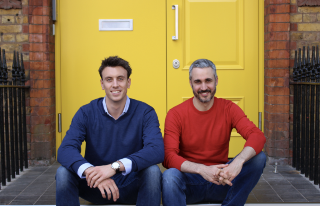 Hometree. Two cofounders sit on a doorstep in front of a bright yellow door