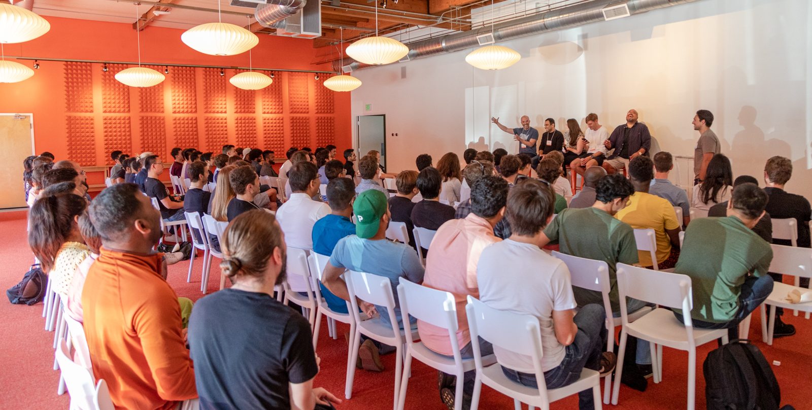 A photo of an audience listening to members of the Y Combinator team 